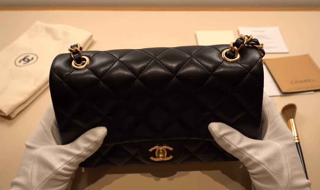흰 장갑을 끼고 명품 가방의 상태를 검수하는 모습